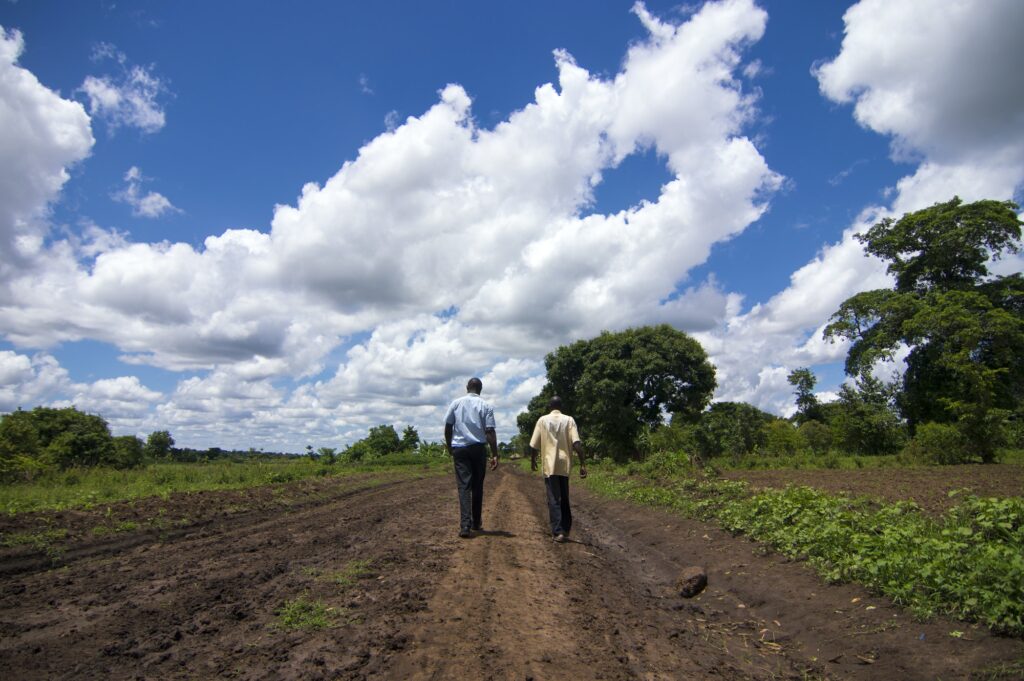 African NGO workers walking down a road in rural Uganda.